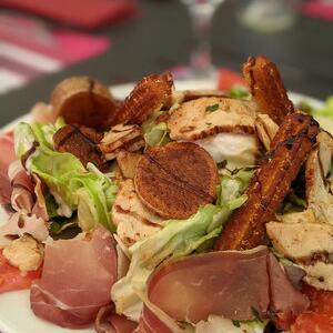 Traditional duck confit with salad, served at the restaurant of Camping Le Séquoïa in the Dordogne Valley.