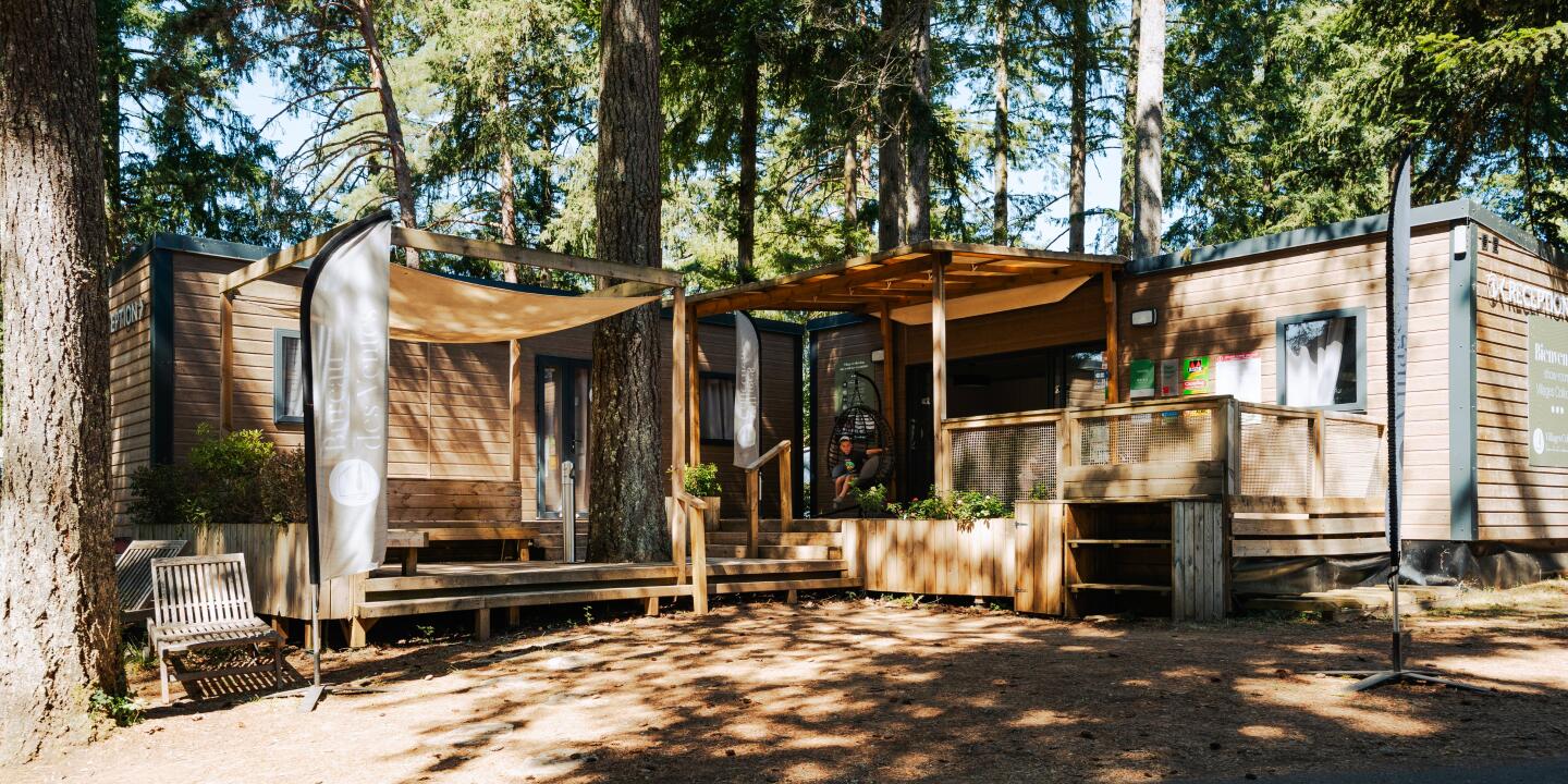 Reception building at Camping Le Séquoïa surrounded by trees