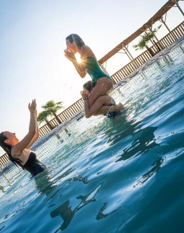 Amis profitant d’une journée ensoleillée au bord de la lagune naturelle du Camping Le Séquoïa, dans la Vallée de la Dordogne.