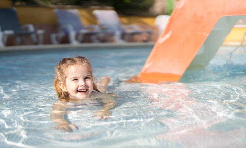 Jeune enfant s’amusant dans la pataugeoire avec toboggan