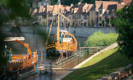 Houten gabarreboten aangemeerd langs de rivier de Dordogne voor het dorp La Roque-Gageac, een van de mooiste dorpen van Frankrijk.