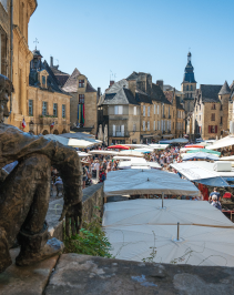Uitzicht over de markt van Sarlat-la-Canéda met het standbeeld van La Boétie op de voorgrond, omringd door middeleeuwse gebouwen in de Dordognevallei.