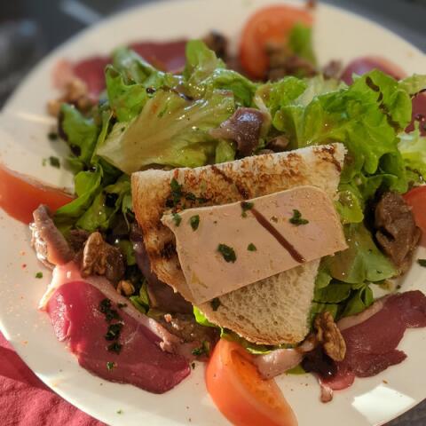 Verse salade met foie gras en lokale ingrediënten, geserveerd in het restaurant van Camping Le Séquoïa in de Dordognevallei.