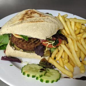 Vegetarische burger met friet, geserveerd in het restaurant van Camping Le Séquoïa in de Dordognevallei, ideaal voor vegetariërs.