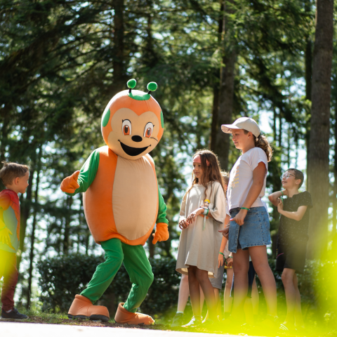 De Sunêlia-mascotte begroet kinderen op Camping Le Séquoïa in het bos van de Dordogne.