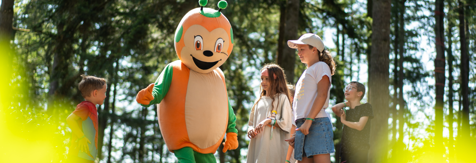 De Sunêlia-mascotte begroet kinderen op Camping Le Séquoïa in het bos van de Dordogne.