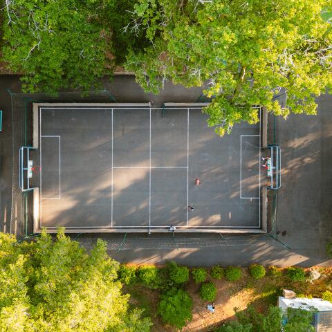 Luchtfoto van het multisportveld op Camping Le Séquoïa voor voetbal, basketbal en groepsspellen.