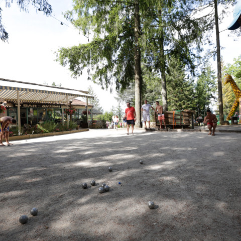 Gasten spelen jeu de boules onder de bomen op Camping Le Séquoïa in een gezellige sfeer.