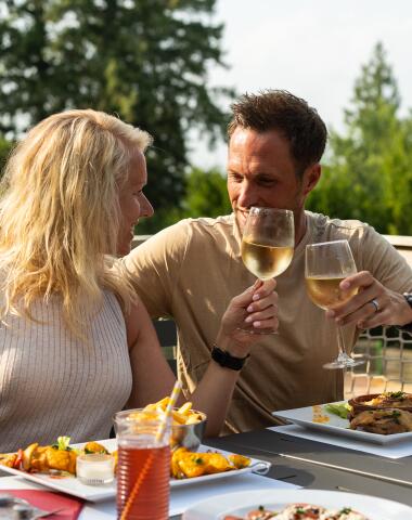 Stel geniet van een maaltijd op het terras tijdens een verblijf op Camping Le Séquoia in de Lot