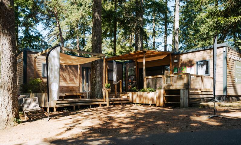 Receptiegebouw van Camping Le Séquoïa tussen de bomen