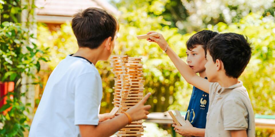Kinderen bouwen een KAPLA-toren bij de kinderclub van Camping Le Séquoïa